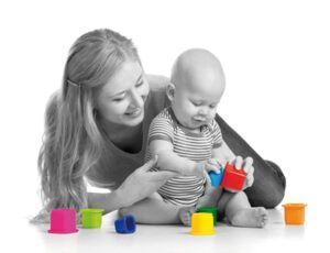 kid boy and mother playing together with cup toys